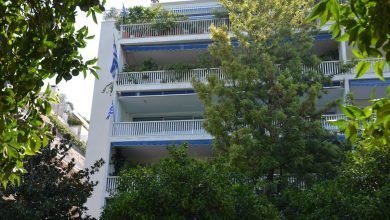 Atina'da ağaçlı bir sokakta balkonlu apartman cepheleri