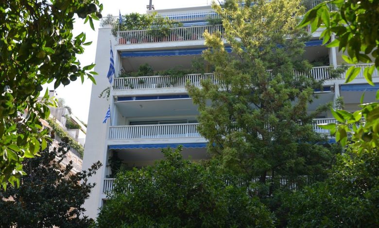 Atina'da ağaçlı bir sokakta balkonlu apartman cepheleri