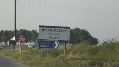 Yunanistan'da yerleşim girişini gösteren yol tabelası ve dur işareti